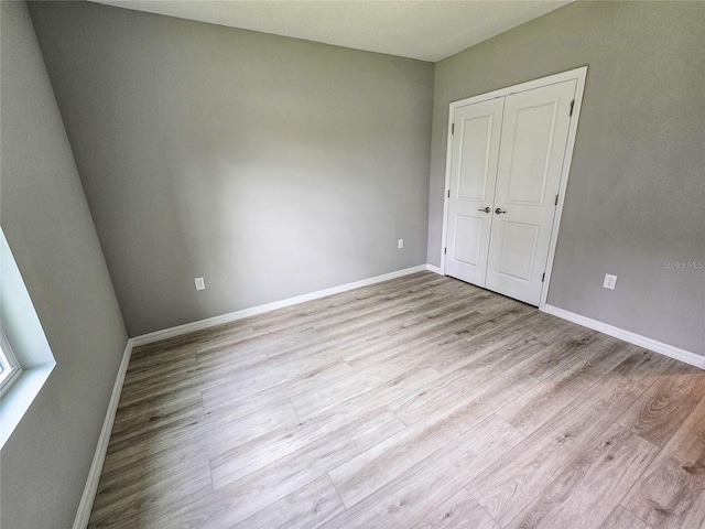 unfurnished bedroom featuring light hardwood / wood-style flooring and a closet