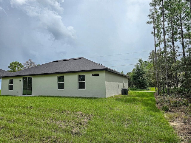 exterior space featuring central AC and a lawn