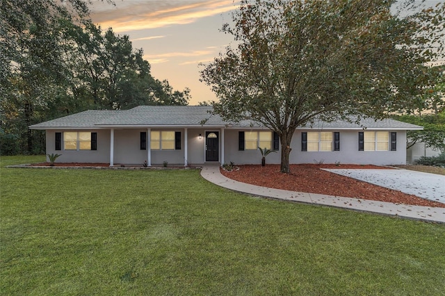 ranch-style home with a lawn