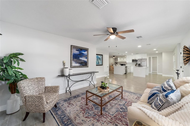 living room with light hardwood / wood-style floors and ceiling fan