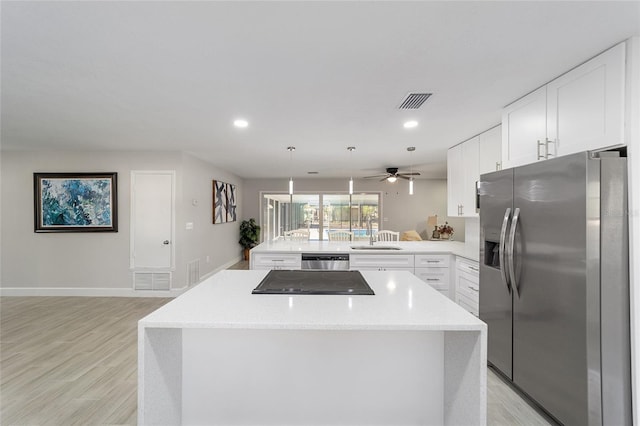 kitchen with pendant lighting, kitchen peninsula, light wood-type flooring, white cabinetry, and stainless steel appliances