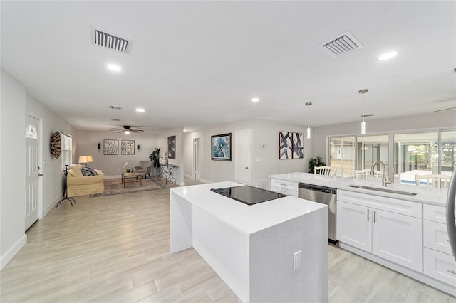 kitchen with stainless steel dishwasher, ceiling fan, sink, a center island, and white cabinetry