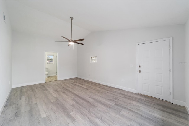 spare room with ceiling fan, lofted ceiling, and light wood-type flooring