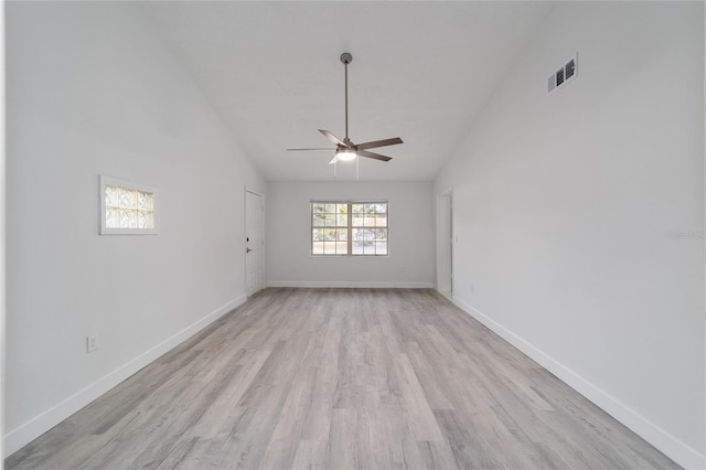 empty room with light wood-type flooring, high vaulted ceiling, and ceiling fan