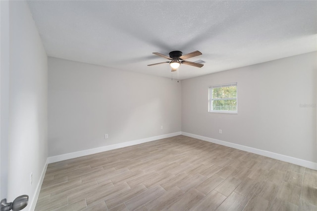 spare room featuring ceiling fan, light hardwood / wood-style floors, and a textured ceiling