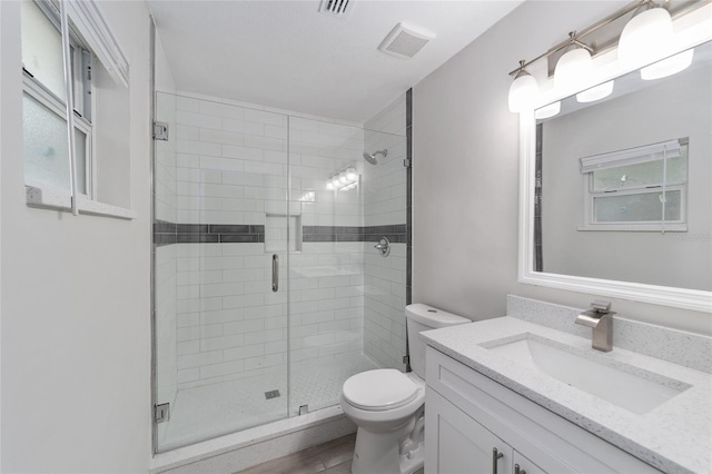 bathroom featuring an enclosed shower, vanity, toilet, and hardwood / wood-style floors