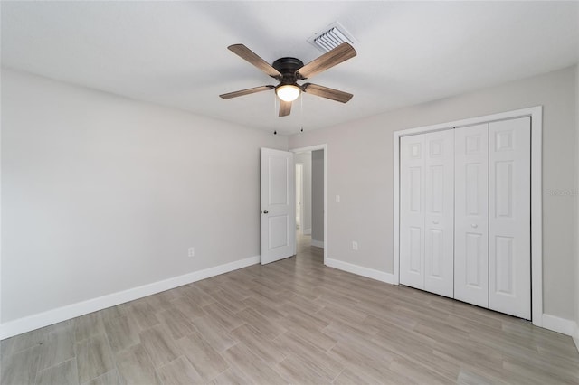 unfurnished bedroom with a closet, light hardwood / wood-style floors, and ceiling fan