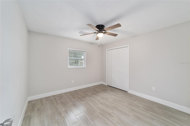 unfurnished bedroom featuring ceiling fan, a closet, and light hardwood / wood-style flooring