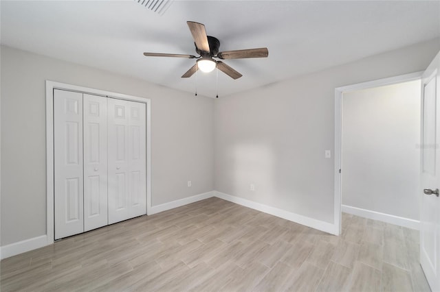 unfurnished bedroom with ceiling fan, light hardwood / wood-style flooring, and a closet