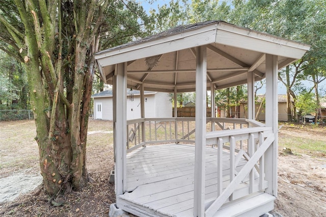 wooden terrace with a gazebo and a storage unit