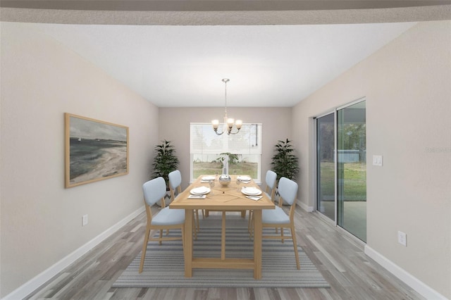 unfurnished dining area featuring a chandelier and wood-type flooring