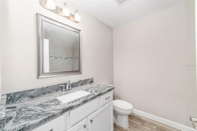 bathroom featuring vanity, hardwood / wood-style flooring, and toilet