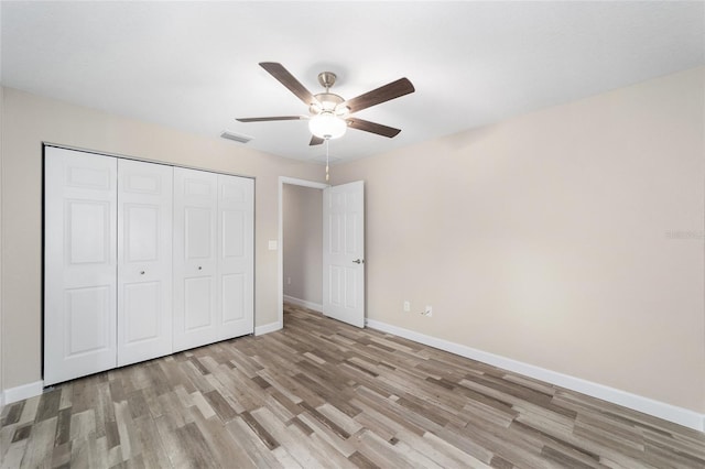 unfurnished bedroom featuring a closet, light hardwood / wood-style flooring, and ceiling fan