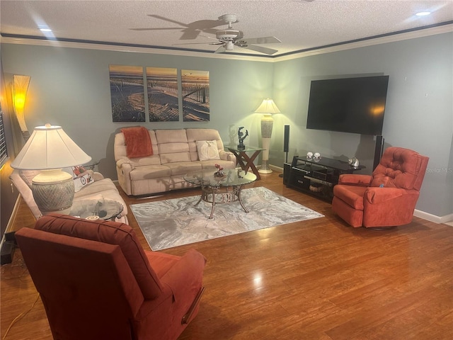 living room with hardwood / wood-style flooring, ceiling fan, ornamental molding, and a textured ceiling