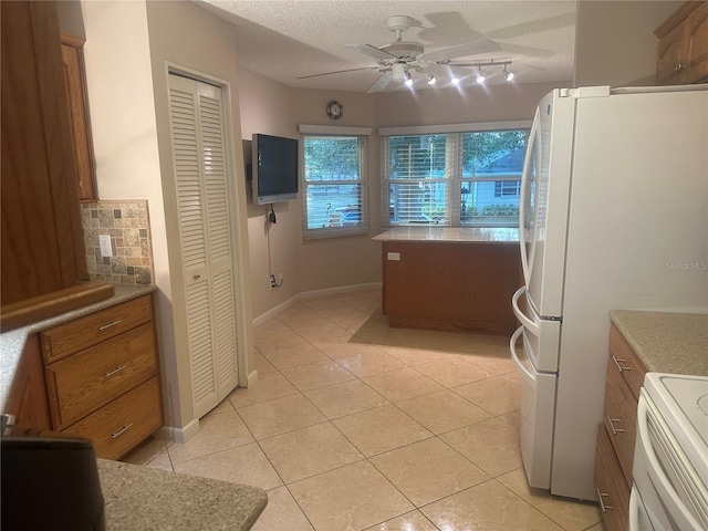 kitchen with ceiling fan, white appliances, light tile patterned floors, and a textured ceiling