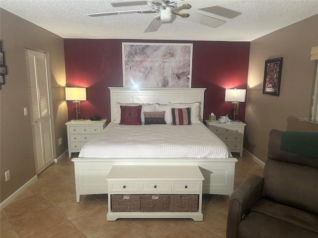 tiled bedroom with ceiling fan, a textured ceiling, and a closet