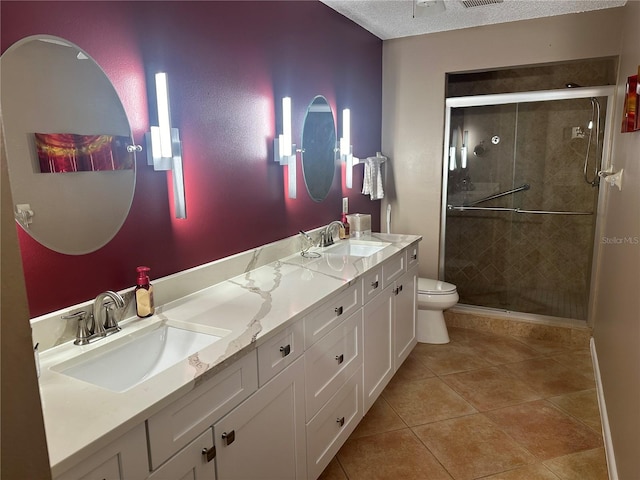 bathroom with vanity, tile patterned floors, toilet, a textured ceiling, and an enclosed shower