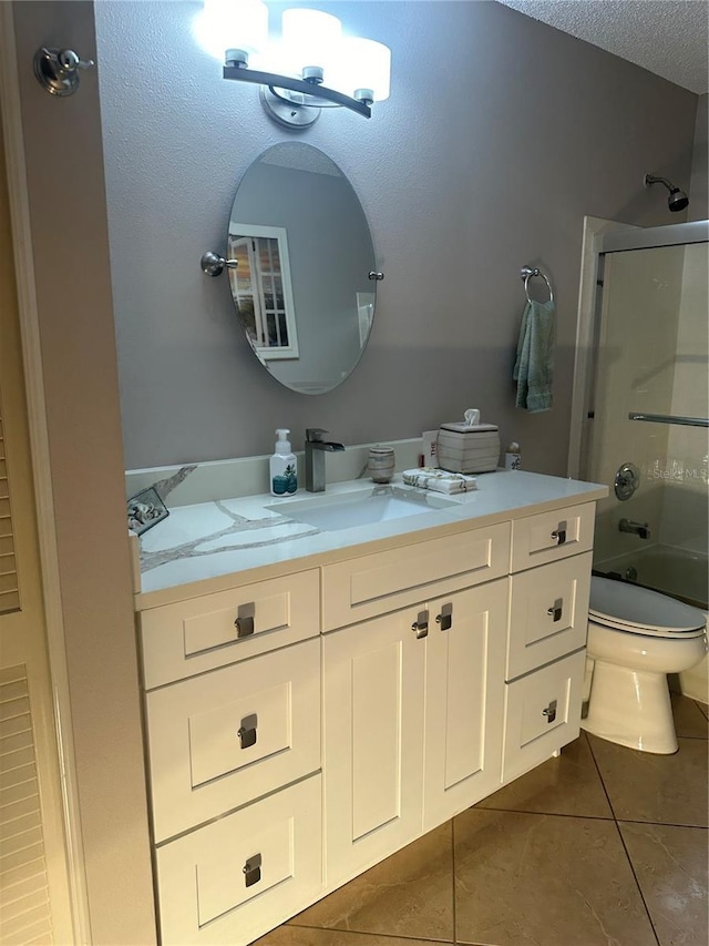 full bathroom with tile patterned flooring, a textured ceiling, toilet, shower / bath combination with glass door, and vanity