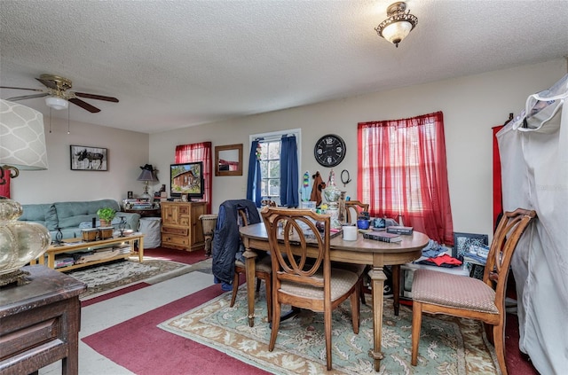 dining room featuring carpet flooring, ceiling fan, and a textured ceiling