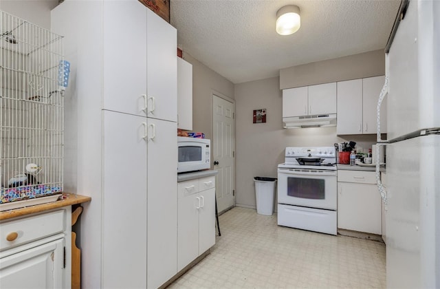 kitchen featuring a textured ceiling, white cabinets, and white appliances