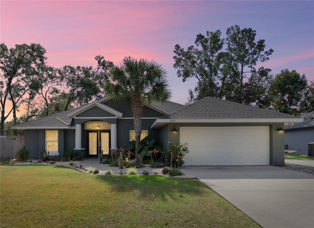 view of front of property featuring a garage and a lawn