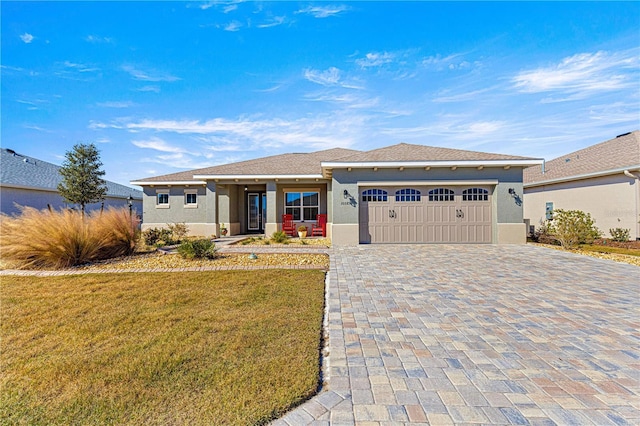 view of front of property with a garage and a front lawn