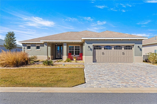 view of front facade featuring a front yard, a garage, and covered porch