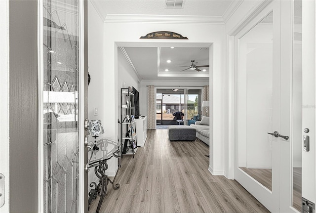 foyer entrance with light hardwood / wood-style flooring, ceiling fan, and crown molding