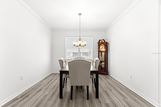 dining area with light wood-type flooring, an inviting chandelier, and crown molding