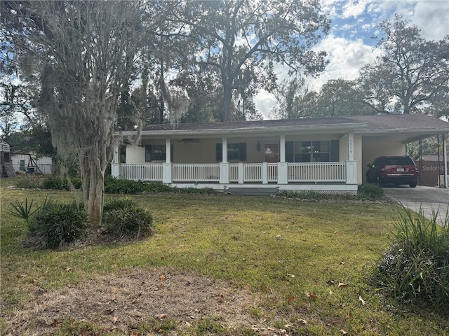 view of front facade with a front yard, a carport, and covered porch