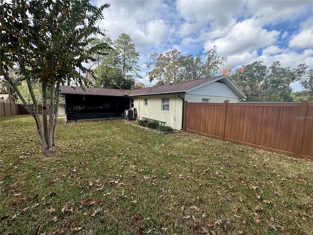 back of house with a lawn and central AC