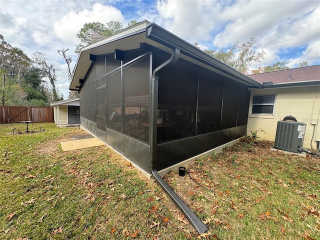 exterior space featuring a yard, central AC, and a sunroom