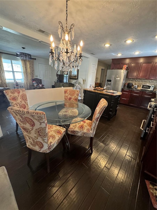 dining space with a notable chandelier, dark hardwood / wood-style floors, and a textured ceiling