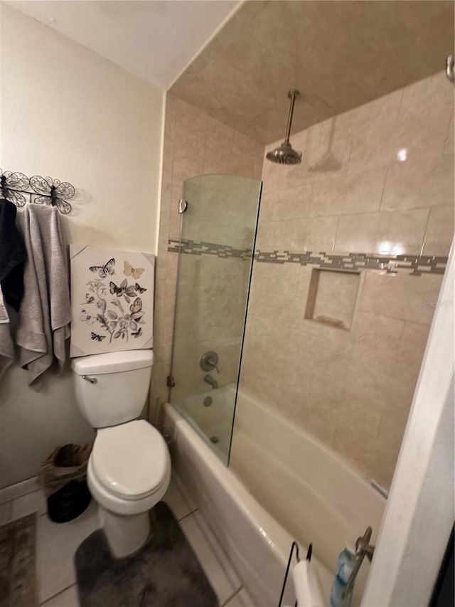 bathroom featuring tile patterned floors, tiled shower / bath combo, and toilet