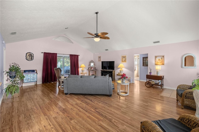 living room with ceiling fan, hardwood / wood-style floors, and high vaulted ceiling