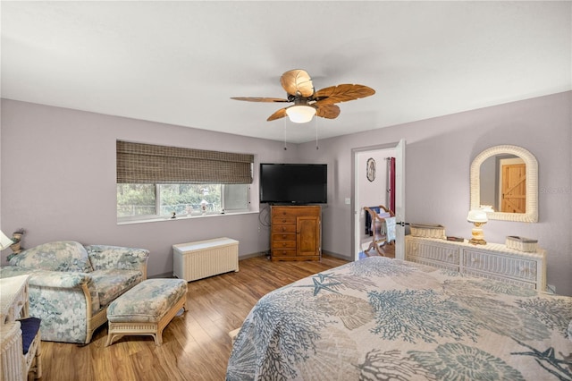 bedroom with radiator, ceiling fan, and light wood-type flooring