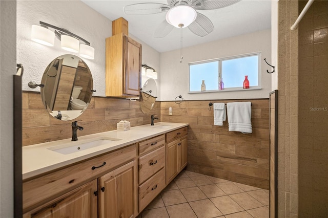 bathroom featuring tile patterned floors, vanity, ceiling fan, tile walls, and toilet