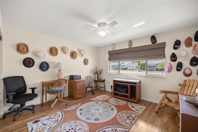 living area with hardwood / wood-style floors and ceiling fan