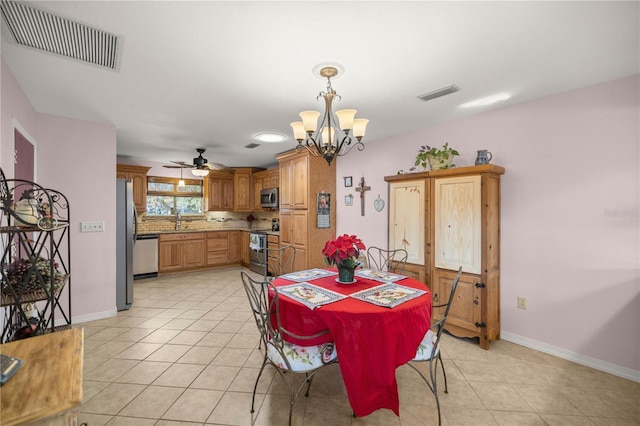 tiled dining area featuring ceiling fan with notable chandelier and sink