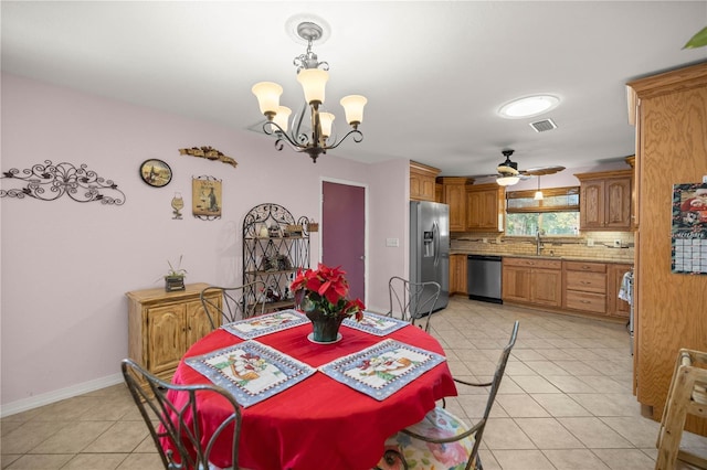 tiled dining space with sink and ceiling fan with notable chandelier