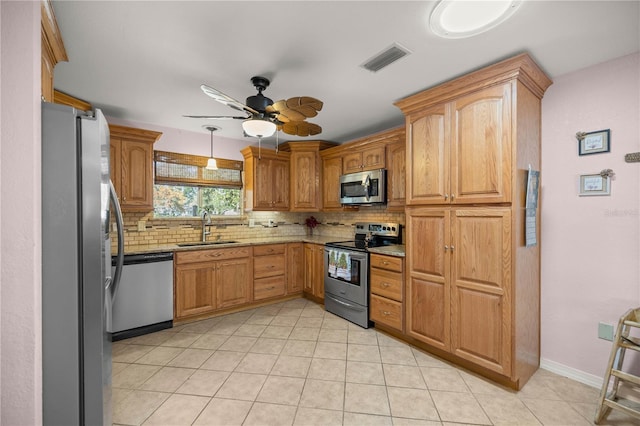 kitchen with backsplash, light stone counters, stainless steel appliances, ceiling fan, and sink