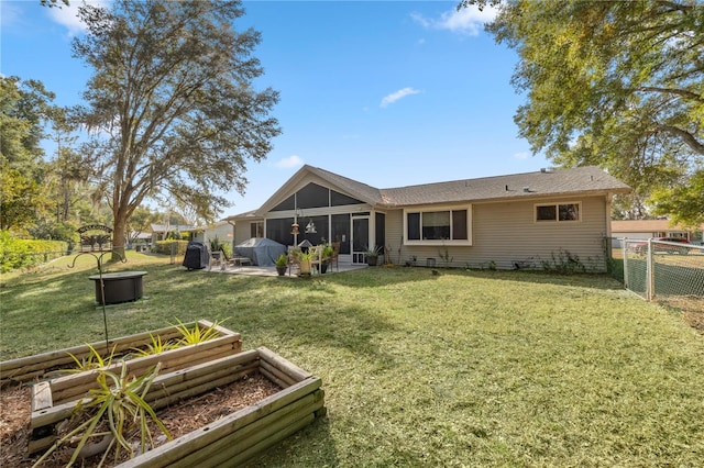 rear view of property with a patio, a lawn, and a sunroom