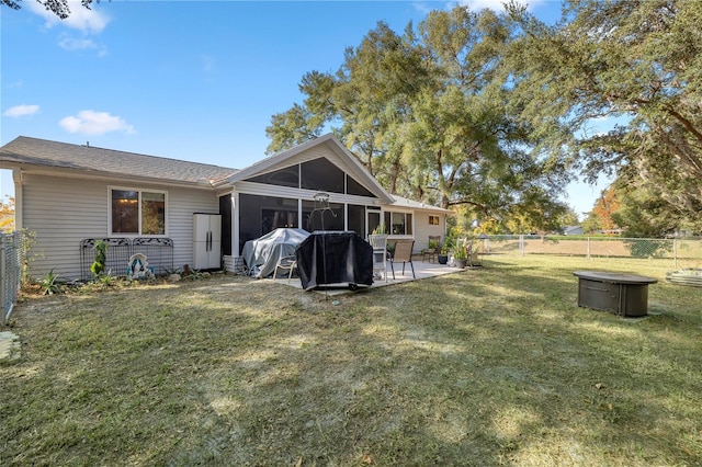 rear view of house with a sunroom, a patio area, and a yard