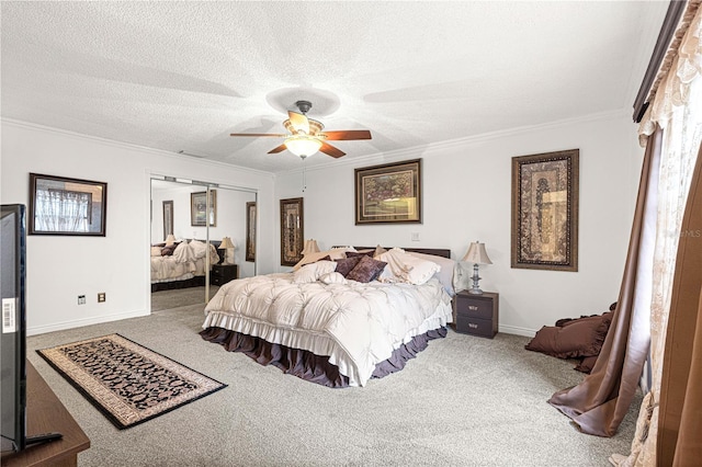 carpeted bedroom with ceiling fan, a closet, a textured ceiling, and ornamental molding