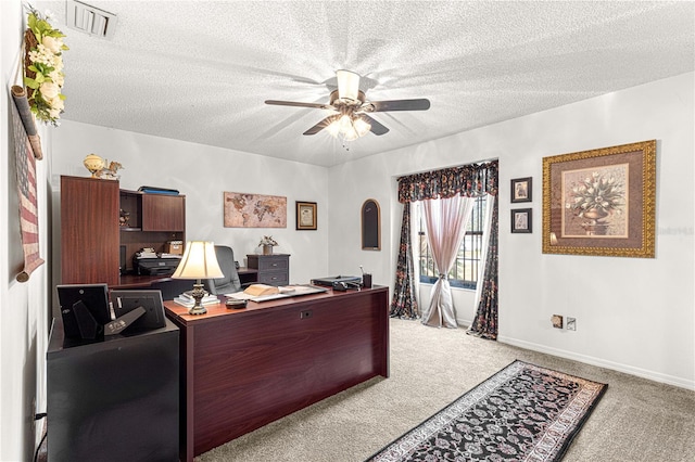 office area with ceiling fan, carpet floors, and a textured ceiling