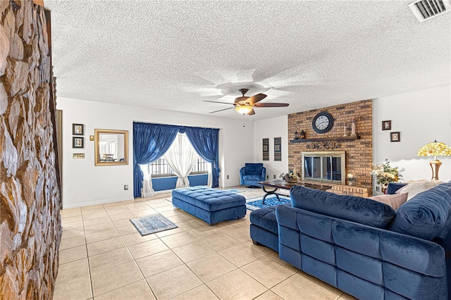 living room with ceiling fan, light tile patterned flooring, and a brick fireplace