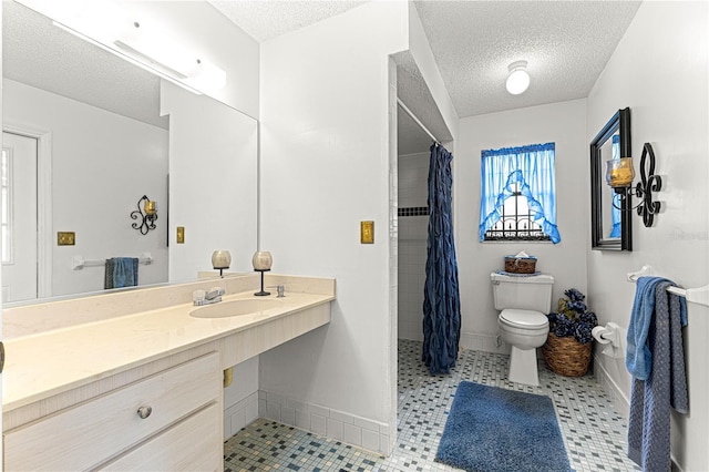 bathroom featuring a textured ceiling, toilet, walk in shower, and sink