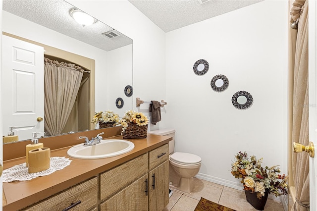 bathroom with tile patterned flooring, vanity, toilet, and a textured ceiling