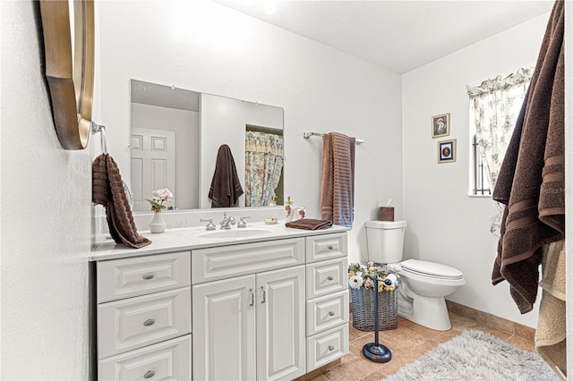 bathroom featuring tile patterned flooring, vanity, and toilet