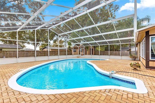 view of swimming pool with glass enclosure and a patio area